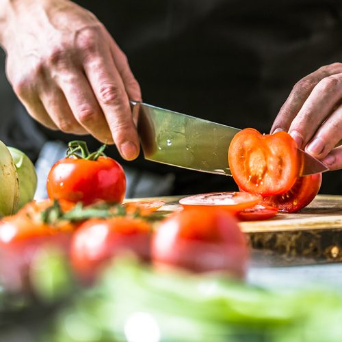 Chefkoch in der Küche mit Frischem Gemüse(Tomaten)